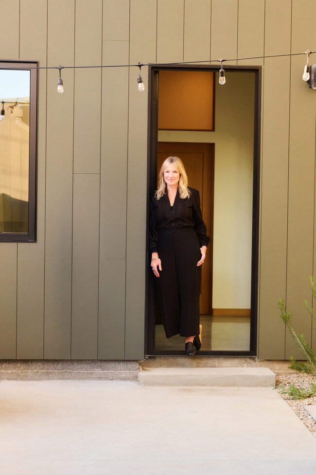 Social media photographer in Los Angeles, full-body personal brand portrait of a woman standing in a modern architectural doorway, lifestyle content photo for Instagram, websites, and digital marketing.