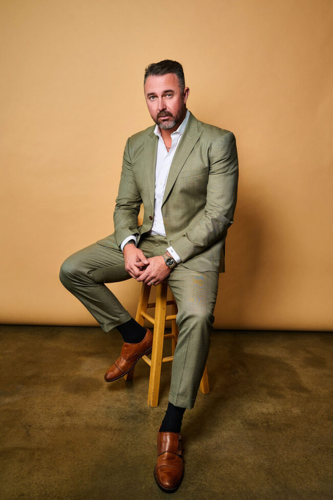 Social media photographer in Los Angeles, editorial executive portrait of a man in a green suit seated in studio against a warm neutral backdrop, content photo for Instagram, websites, LinkedIn, and digital marketing.